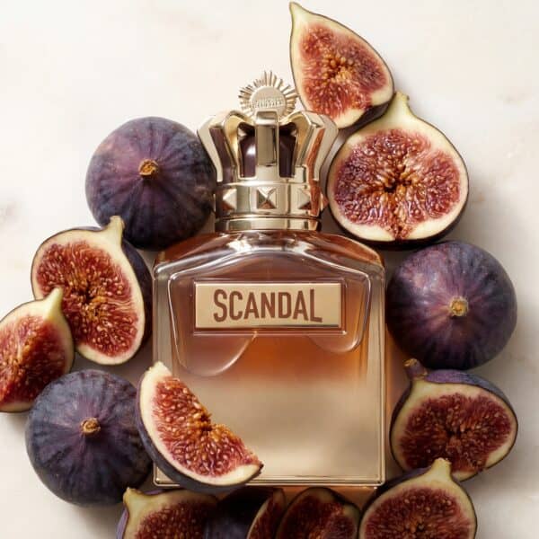 19 Fig perfume bottle labeled "SCANDAL" surrounded by fresh figs for a luxurious fragrance experience.